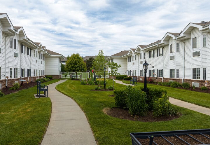 Paved Walkway with Benches and Greenery Between Buildings in Assisted Living Paved Walkway with Benches and Greenery Between Buildings in Assisted Living