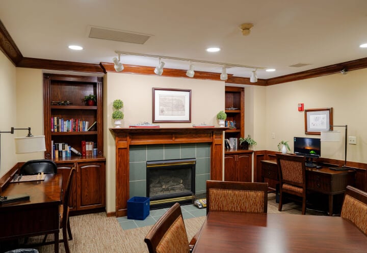 Quiet Library Lounge with Bookshelves and Fireplace at Assisted Living Facility Quiet Library Lounge with Bookshelves and Fireplace at Assisted Living Facility