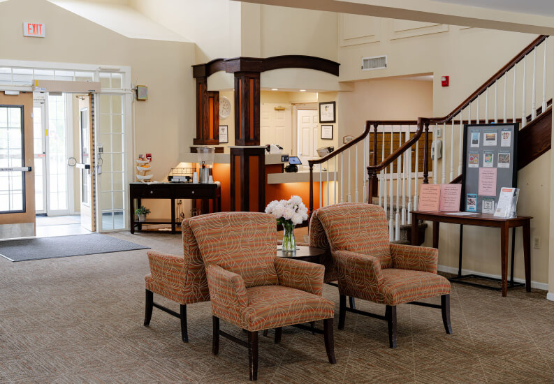 Welcoming Reception Lobby with Seating and Staircase in Assisted Living Community Welcoming Reception Lobby with Seating and Staircase in Assisted Living Community