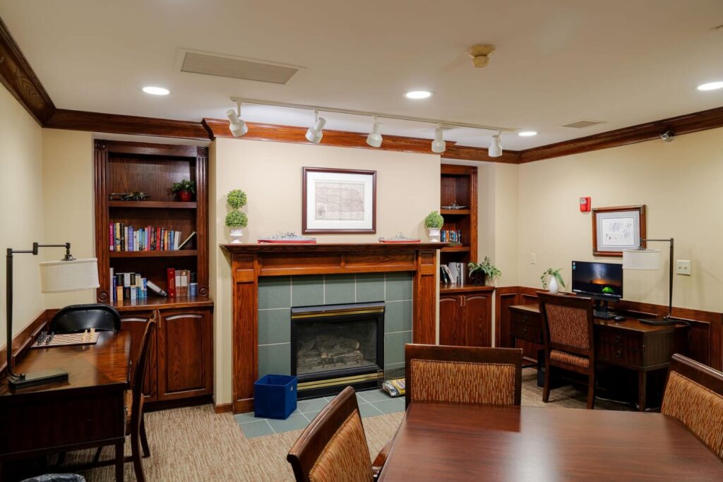 Quiet Library Lounge with Bookshelves and Fireplace for Elderly Assisted Living Care