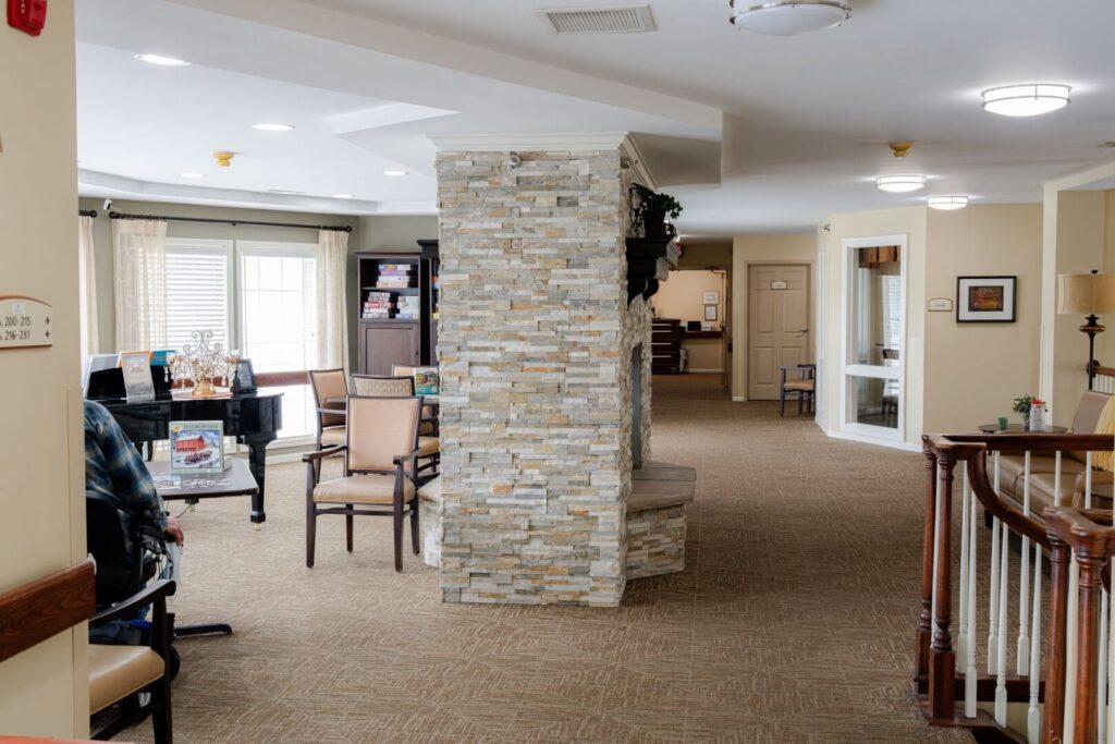 Open Common Area with Stone Fireplace and Grand Piano in Assisted Living