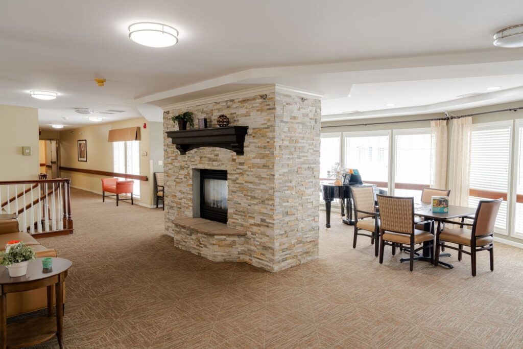 Spacious Lounge with Stone Fireplace and Dining Seating at Assisted Living Facility